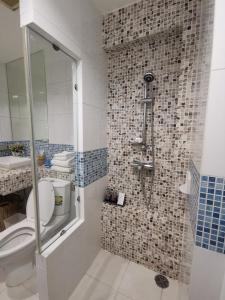 een badkamer met een toilet en een douche met tegels bij The Beach Bangsaen Condo Sea View Room 327-62 Floor 7 in Ban Bang Saen (1)