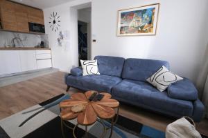 a living room with a blue couch and a table at Vila Kaja - self check in - free parking in Zagreb