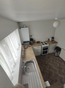uma pequena cozinha com um lavatório e um fogão em Homestay near a station and park em Longbridge