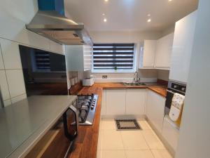 a kitchen with white cabinets and a stove top oven at 2. Comfy Professional Room [ NHS & TRADES welcome] Beds , Milton Keynes & Silverstone in Luton