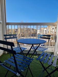 a table and chairs on a balcony with a table and chairs at L'Escapade Gruissanaise, appartement 1 chambre, loggia, climatisation, wifi avec piscines de mi-mai à mi-septembre dans résidence in Gruissan