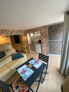 a living room with a table and a couch at And&Col Jardin ,terrasse & climatisation in Marseille