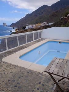 una piscina con un banco y el océano en Casa lucas, en Almáciga