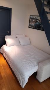 a large white bed in a white room with a picture at triplex, centre-ville, terrasse in Nogent-sur-Marne