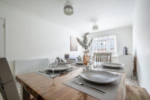 a dining room with a table with plates and wine glasses at Pass the Keys Bright holiday apartment near the beach in Dawlish