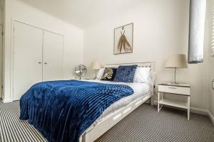 1 dormitorio con 1 cama con manta azul en Pass the Keys Bright holiday apartment near the beach, en Dawlish