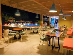 a restaurant with tables and chairs and a pool at Trip Monkey del Río in San Gil