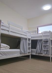 two bunk beds in a room with a window at Urban Heaven, Luxury Hostel - JBR - Walk To Beach, Metro Station in Dubai