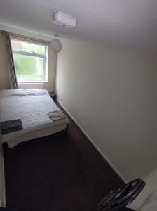 a small bedroom with a bed and a window at Homestay near a station and park in Longbridge