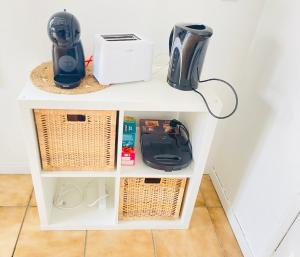a white shelf with baskets and appliances on it at Maison Individuelle Cozy Asterix, CDG, Paris, Disney, Olympic Games 2024 in La Chapelle-en-Serval