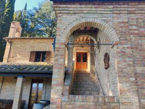 a brick building with a wooden door and stairs at Borgo La Torre alle Tolfe in Siena