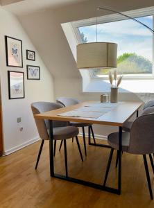 a dining room table with chairs and a window at Stadtvilla Hameln in Hameln