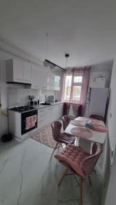 a kitchen with a table and two chairs and a table at Apartament pe pietonala nr1 in Hunedoara