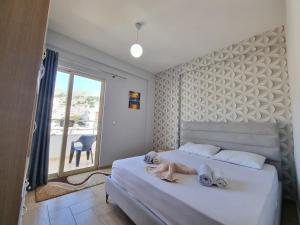 a bedroom with a bed with a doll on it at Lea Apartament in Sarandë