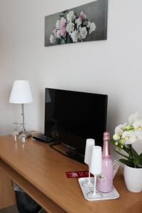 een bureau met een televisie en een lamp en bloemen bij Landhaus Ellernkrug Hotel in Lage