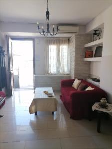 a living room with a red couch and a table at PERGAMOS APARTMENTS in Mytilene