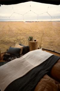 a bed in a room with a view of a field at Helja Stay Glamping Domes in Hella