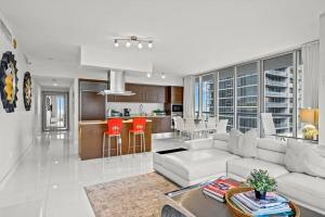 a living room with a white couch and a kitchen at 44th FLOOR CORNER 2 BDR• ICON BRICKELL• OCEAN VIEW AND FREE SPA in Miami