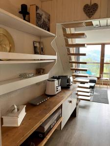 eine Küche mit weißen Regalen und eine Treppe in der Unterkunft Duplex Belles Challes in Bourg-Saint-Maurice