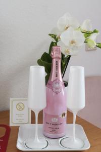 a pink bottle on a table with two glasses at Landhaus Ellernkrug Hotel in Lage