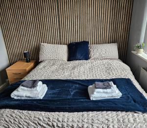 1 dormitorio con 1 cama con toallas en Aldwych house, For Holidays, Contractors & Relocation, Free Parking & Wi-Fi en Preston