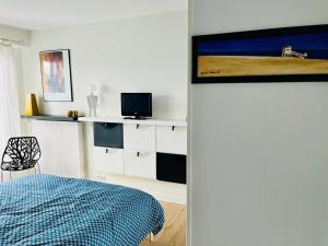 a bedroom with a bed and a tv on a wall at Champs de mars Appartement 1 chambre proche centre ville, balcon et parking in La Rochelle
