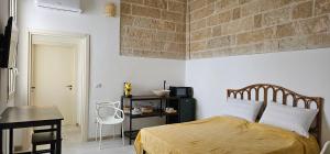 a bedroom with a bed with a brick wall at Mar Bello in Parabita