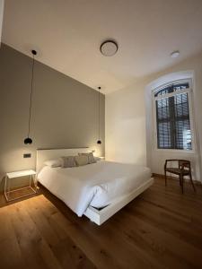 a bedroom with a large white bed and a window at Residenza la Torretta in Domodossola
