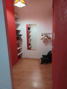 um corredor com um espelho e uma parede vermelha em Casa Catalina zona sur em Comodoro Rivadavia