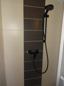 een douche met een zwarte douchekop in de badkamer bij ideal appartement au calme prés du Golf in La Grande-Motte