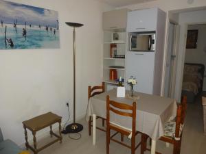 una cucina e una sala da pranzo con tavolo e sedie di ideal appartement au calme prés du Golf a La Grande-Motte