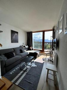 ein Wohnzimmer mit einem Sofa und einem großen Fenster in der Unterkunft Duplex Belles Challes in Bourg-Saint-Maurice