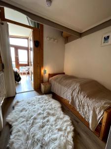 ein Schlafzimmer mit einem großen Bett mit einem pelzigen Teppich in der Unterkunft Duplex Belles Challes in Bourg-Saint-Maurice