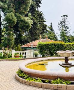 a fountain in a park with a building in the background at Elegant Sea View Retreat in Historic Villa with Pool in Bordighera