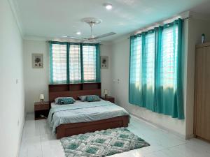 een slaapkamer met een groot bed en blauwe gordijnen bij Hidden Gem In Oyibi New 2 Luxury Bedroom Apartment in Aburi