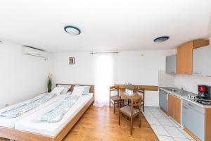 2 łóżka w pokoju z kuchnią w obiekcie Apartman Simic w Trogirze