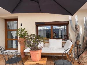 a large black umbrella in a living room with a couch at LE MOULIN DE NAVETTE - La Meule in Aigueblanche