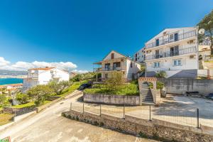 a house on a hill next to the ocean at Apartman Simic in Trogir