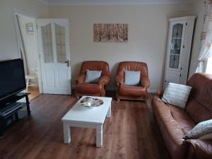 a living room with two couches and a coffee table at Cloonboo Lodge on Wild Atlantic Way Sleeps 12 in Galway