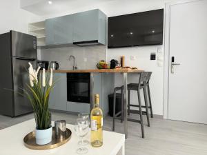 uma cozinha com utensílios de aço inoxidável e uma mesa com copos de vinho em Central Suites Aegina 3 em Egina