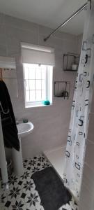 a bathroom with a shower curtain and a sink at Guest suite 50m from the beach in Bognor Regis