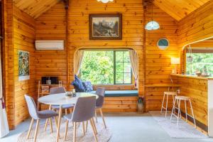 a room with a table and chairs in a cabin at The Birds Nest - Nestled Hideaway in Takaka