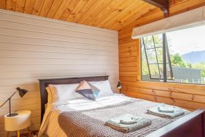 ein Schlafzimmer mit einem Bett mit zwei Handtüchern darauf in der Unterkunft The Birds Nest - Nestled Hideaway in Takaka