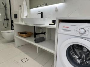 uma casa de banho com uma máquina de lavar roupa e um lavatório em Central Suites Aegina 3 em Egina