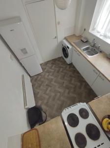 uma pequena cozinha com um fogão e um lavatório em Homestay near a station and park em Longbridge