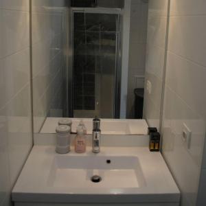 a bathroom with a white sink and a mirror at Rooftop Suresnes in Suresnes