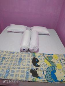 ein Bett mit weißer Bettwäsche und Kissen darauf in der Unterkunft D' pamor Homestay in Halangan