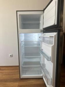 an empty refrigerator with its door open in a kitchen at 20% Discount! Central Seaside in Varna City