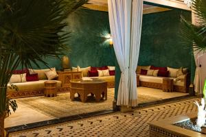 ein Wohnzimmer mit Sofas und einem Tisch in der Unterkunft Riad Tonaroz in Marrakesch