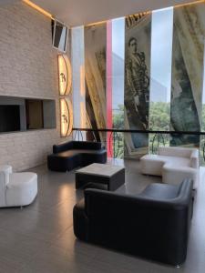 eine Lobby mit Sofas und Tischen in einem Gebäude in der Unterkunft Hotel Villa de Madrid in Mexiko-Stadt
